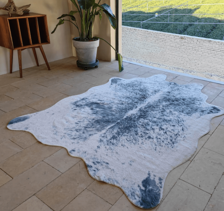 Gray faux cowhide rug styled with potted plants