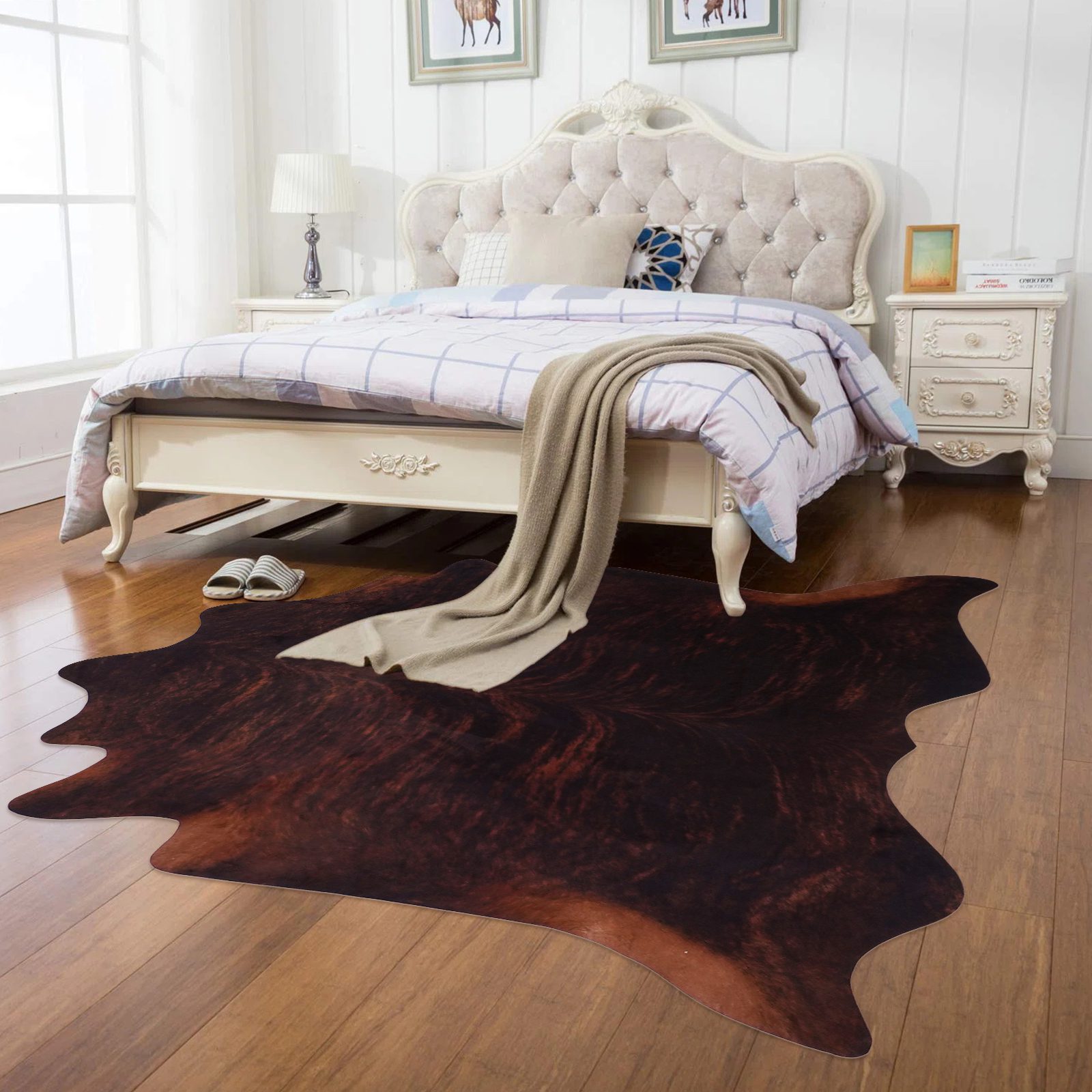 A dark brown cowhide rug under a white bed frame